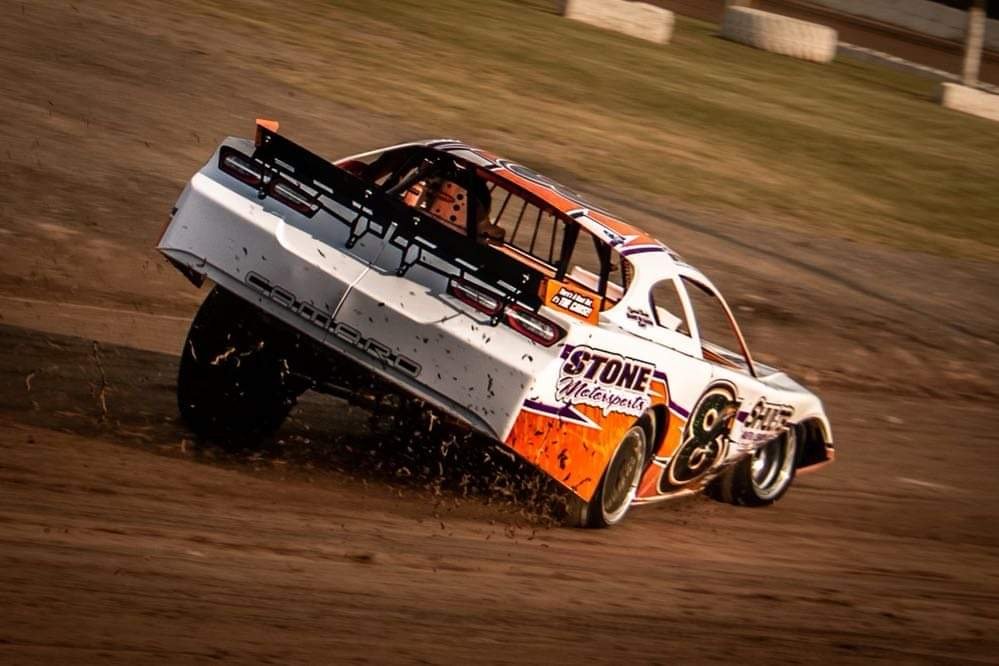 The white and orange 8N throwing dirt off the corner