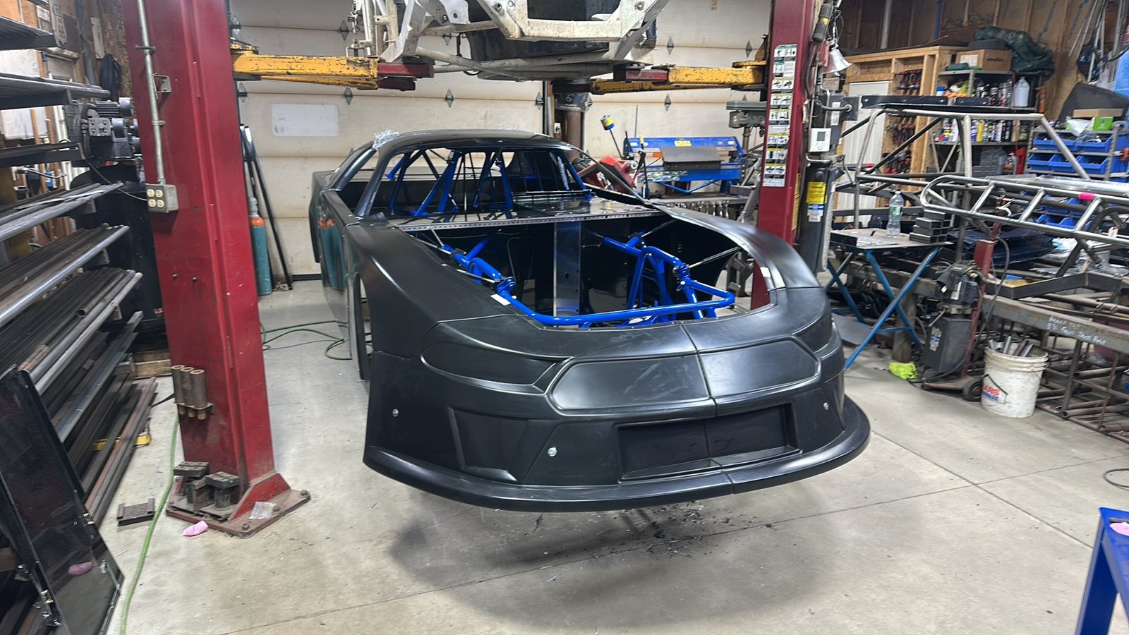 A blue Manimal chassis with its body going on, in Nick's shop