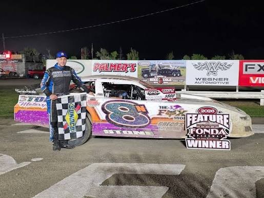 Nick in victory lane at Fonda Speedway in 2026 with the checkered flag